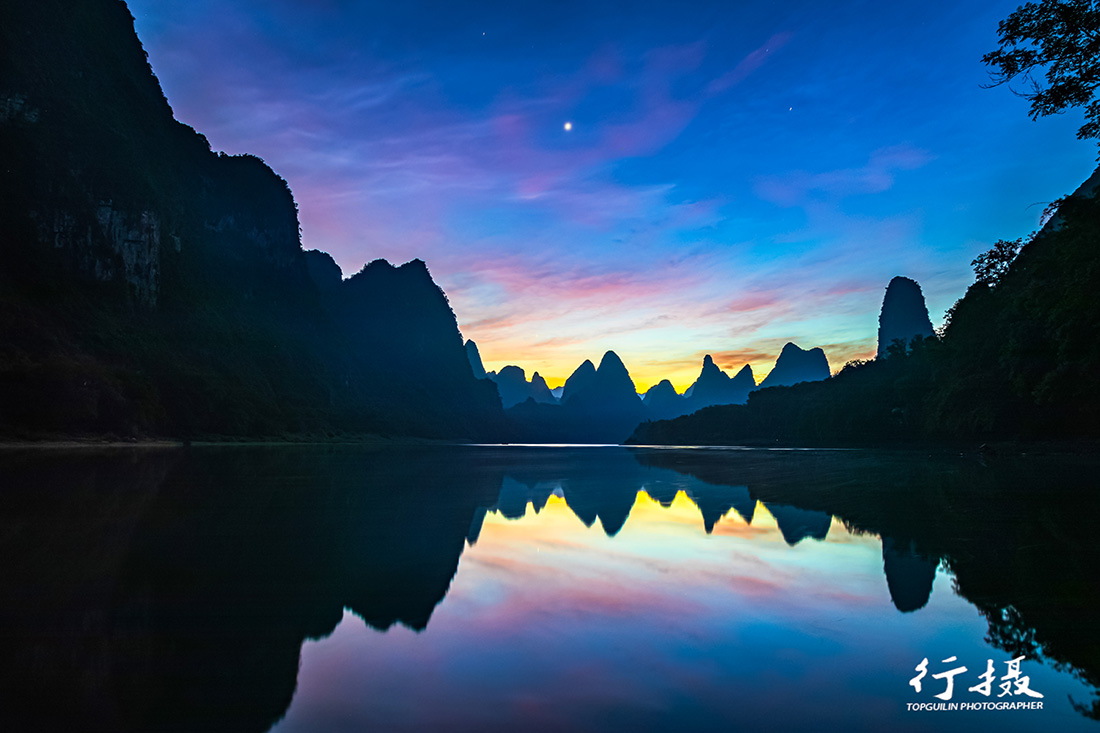 Karst peaks reflected in the still Li River at Xialong near dawn