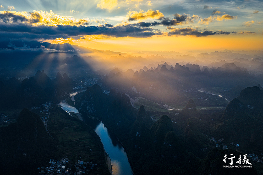 Sunlight breaking through cloud over the Li River and karst peaks from Xianggong Hill