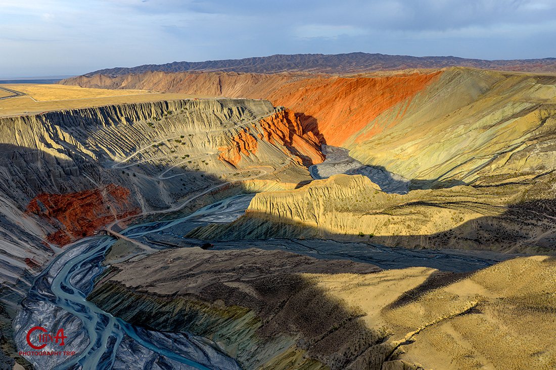 Layered red, ochre and grey strata of Anjihai Grand Canyon seen from the rim