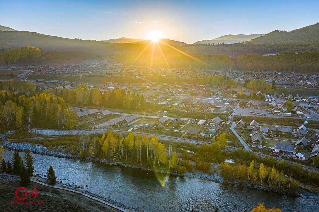 Sunrise over Hemu village seen from the viewing platform, cabins and golden forest below
