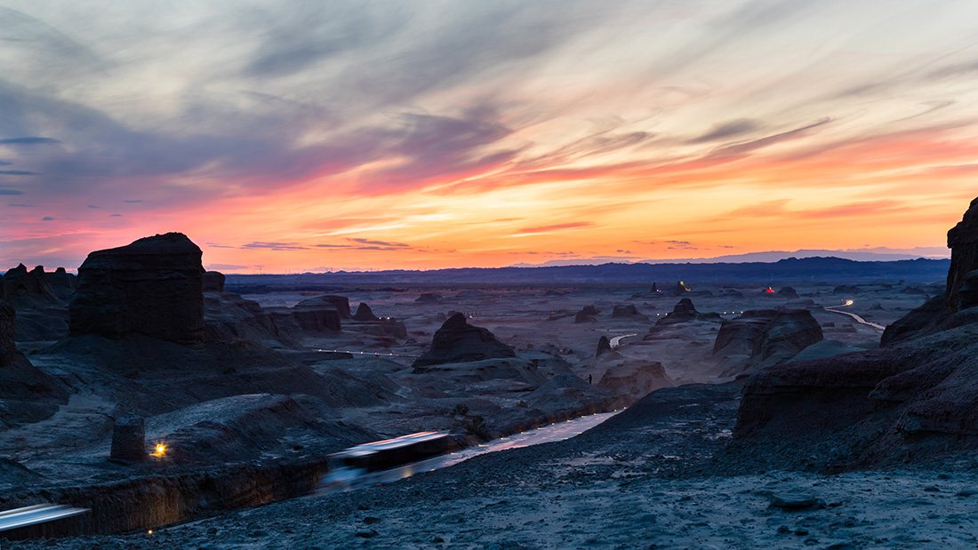 Wind-carved yardang ridges of Urho Ghost City under a deep dusk sky