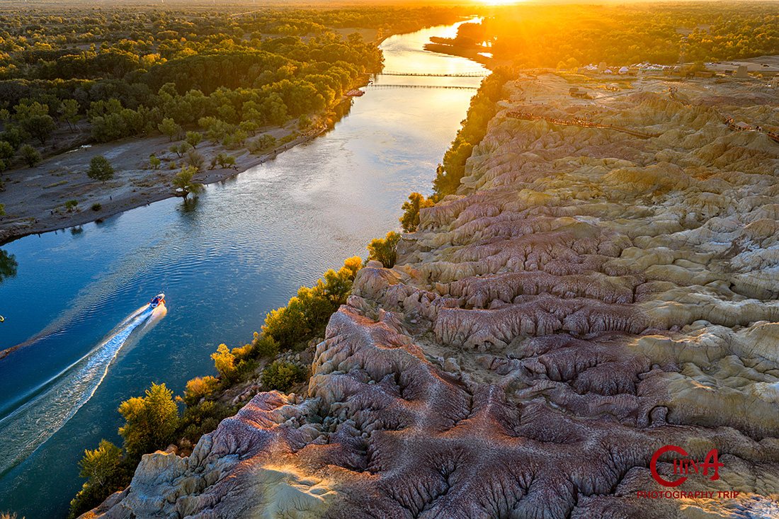 Golden sunset light on the Irtysh River beside the multicoloured cliffs of Wucaitan