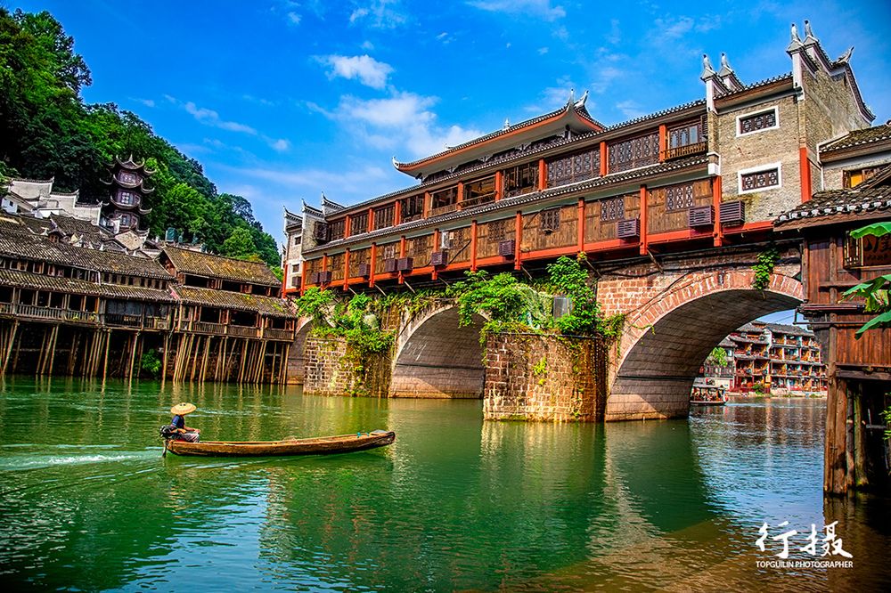 Wooden stilt houses standing in the Tuo River at Fenghuang in daylight