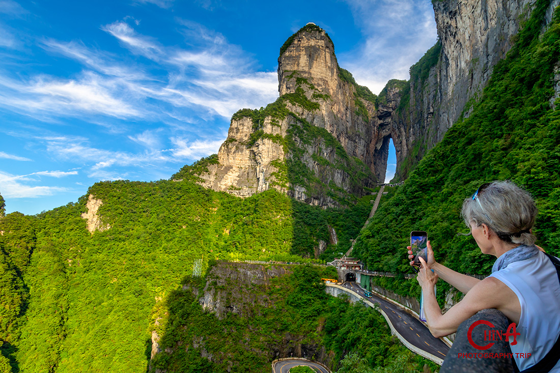 The natural arch of Tianmen Cave seen from below with the stairway